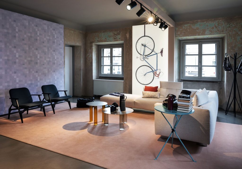 Two Echino coffee table. Round gray top and three semi transparent cilindrical legs in bronze in a living room.