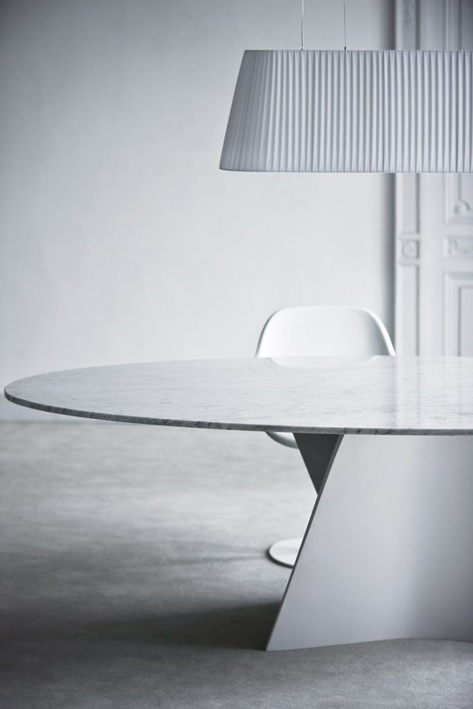 Elica table, white top and central spiral like leg in white in a dining room.