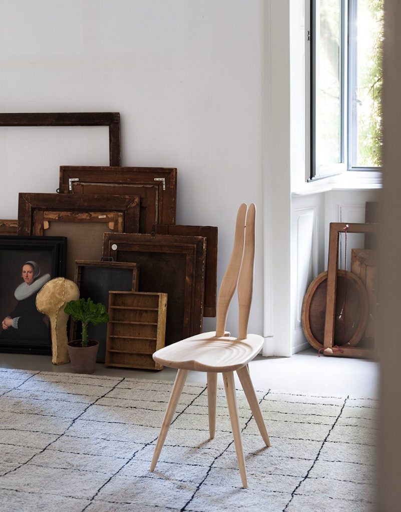 Fenis chair with a natural wooden frame, rabbit ears like shape back in a living room.