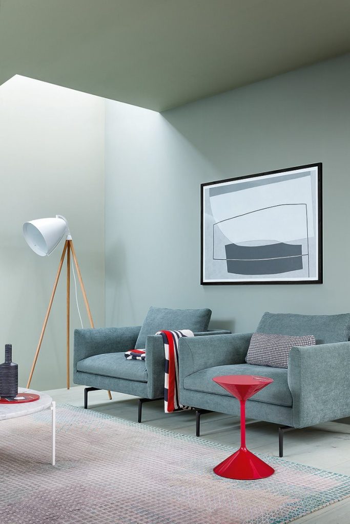 Flamingo sofa upholstered in blue fabric with silver steel legs in a living room.