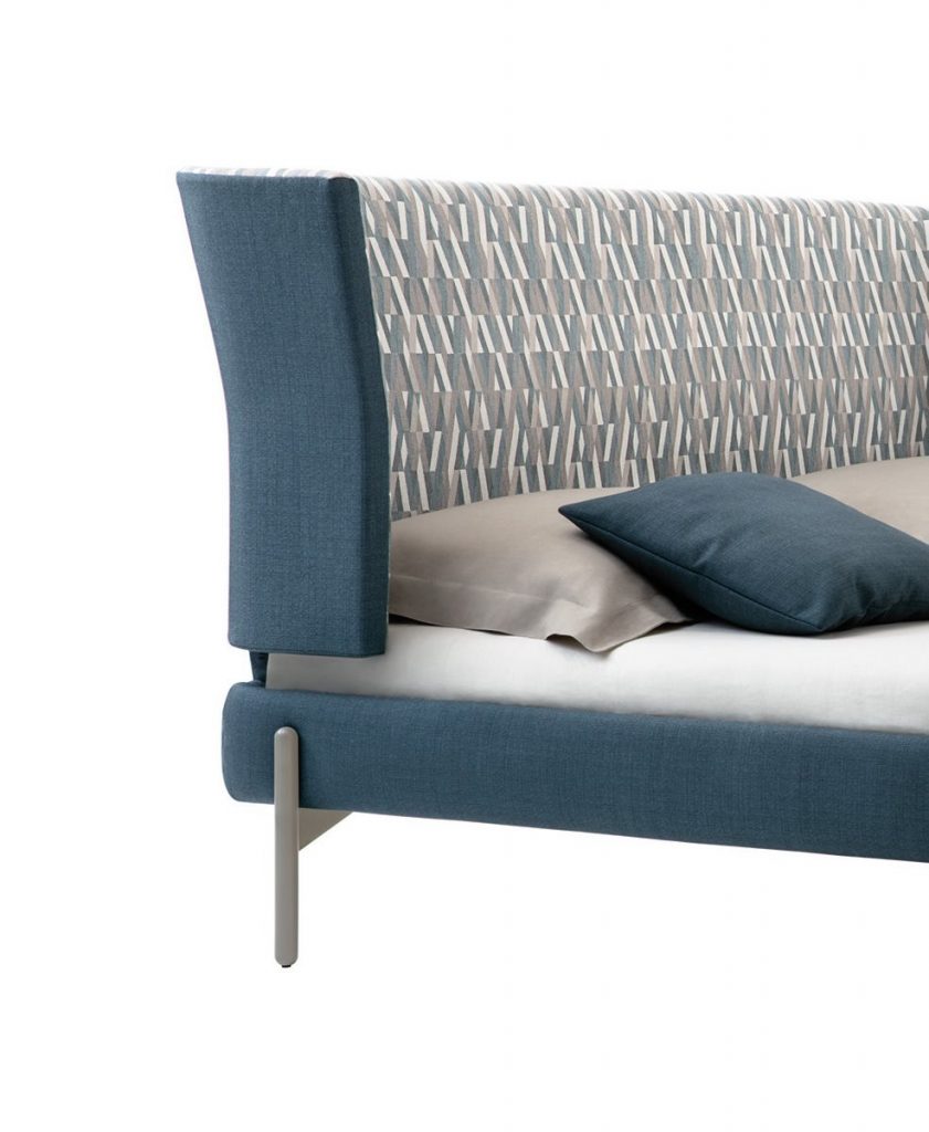 Greta bed with headboard upholstered in blue fabric flower pattern with four silver steel legs on a white background.