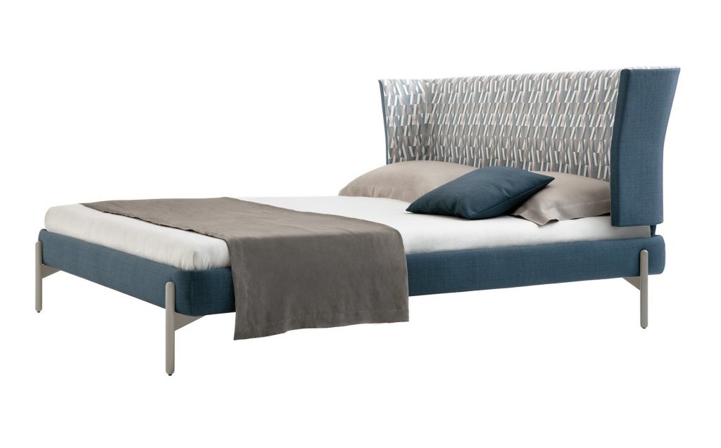Greta bed with headboard upholstered in blue fabric flower pattern with four silver steel legs on a white background.
