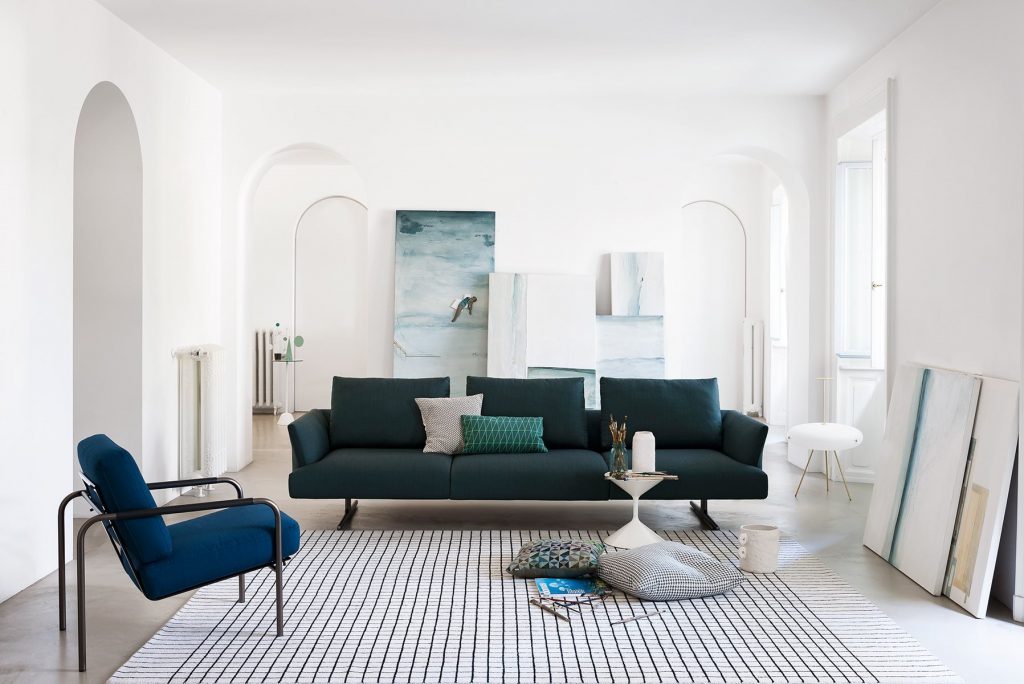 Three seater Hiro sifa with backrest and armrest in green fabric and four black legs in a living room.