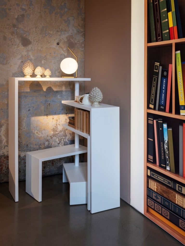 White Joy bookcase with seven moveable shelves around a central tube on a living room.