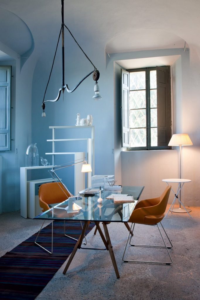 White Joy bookcase with seven moveable shelves around a central tube on a living room.