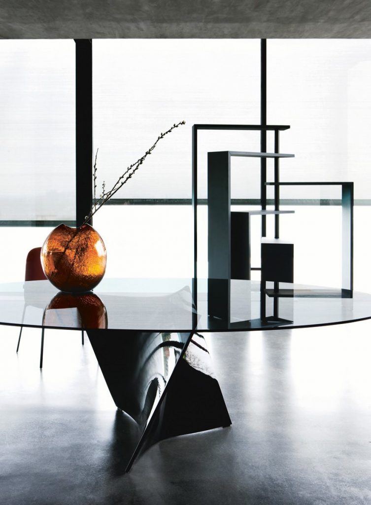 Black Joy bookcase with seven moveable shelves around a central tube on a dining room.