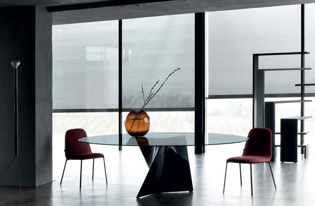 Black Joy bookcase with seven moveable shelves around a central tube on a dining room.