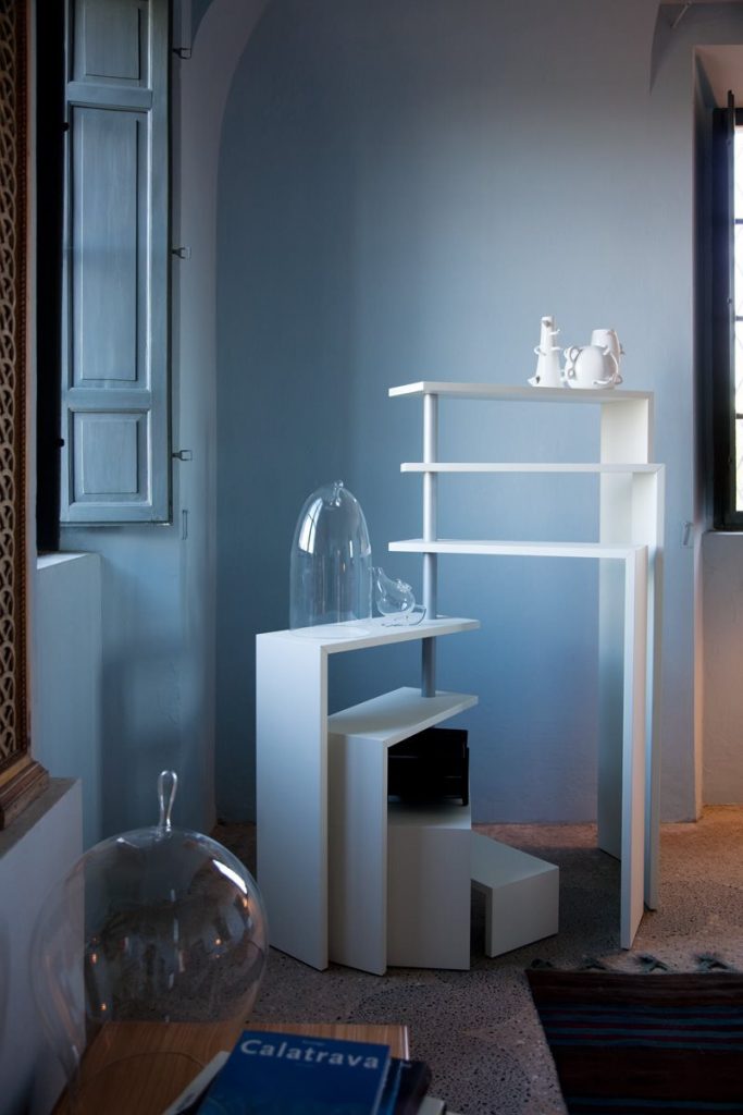 White Joy bookcase with seven moveable shelves around a central tube on a living room.