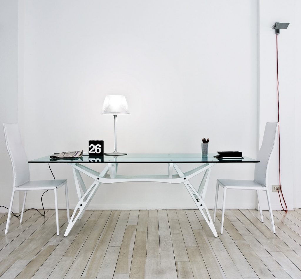 Two Lealta chairs featuring a high backrest and a upholstered seat and backrest in white fabric with four white legs in a dining room.
