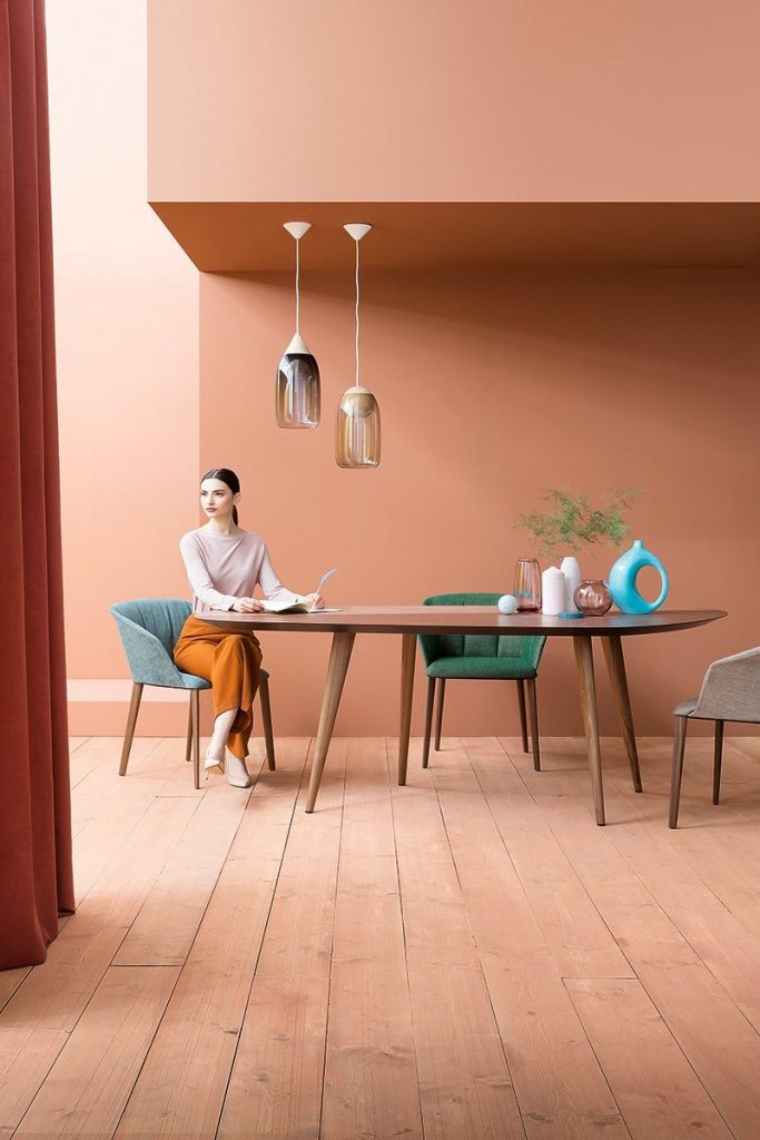 Two Liza 2271 - 2271R chairs featuring a gray cushioned seat, armrest and backrest with four natural wood legs in a dining room.