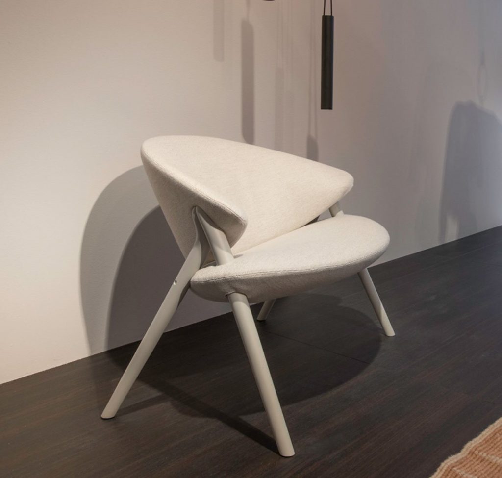 Oliva chair featuring a white frame and a white upholstered seat and backrest a living room.