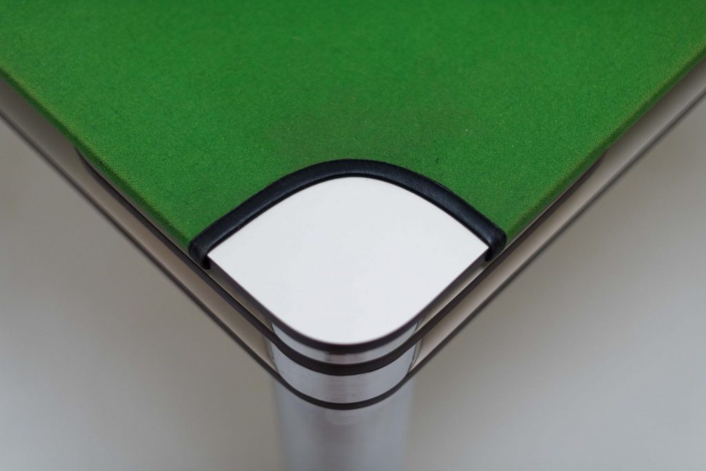 Closeup of Poker table with a sleek black metal frame and green top fabric.