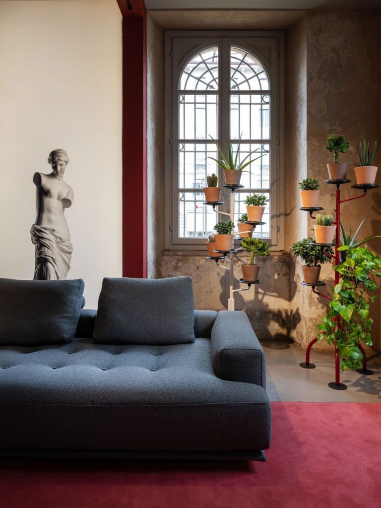 Shiki sofa upholstered in blue with cushions in a living room.