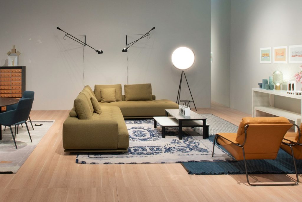 Shiki sofa upholstered in brown with cushions in a living room.