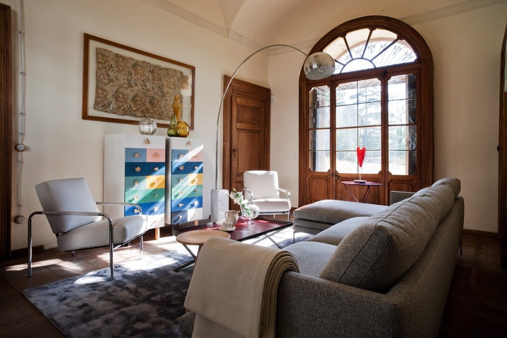 Two Susanna lounge chairs with a sleek metal frame and light gray cushioned seat and backrest in a living room.
