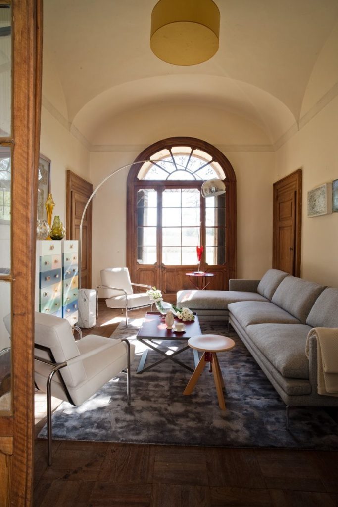 Two Susanna lounge chairs with a sleek metal frame and light gray cushioned seat and backrest in a living room.