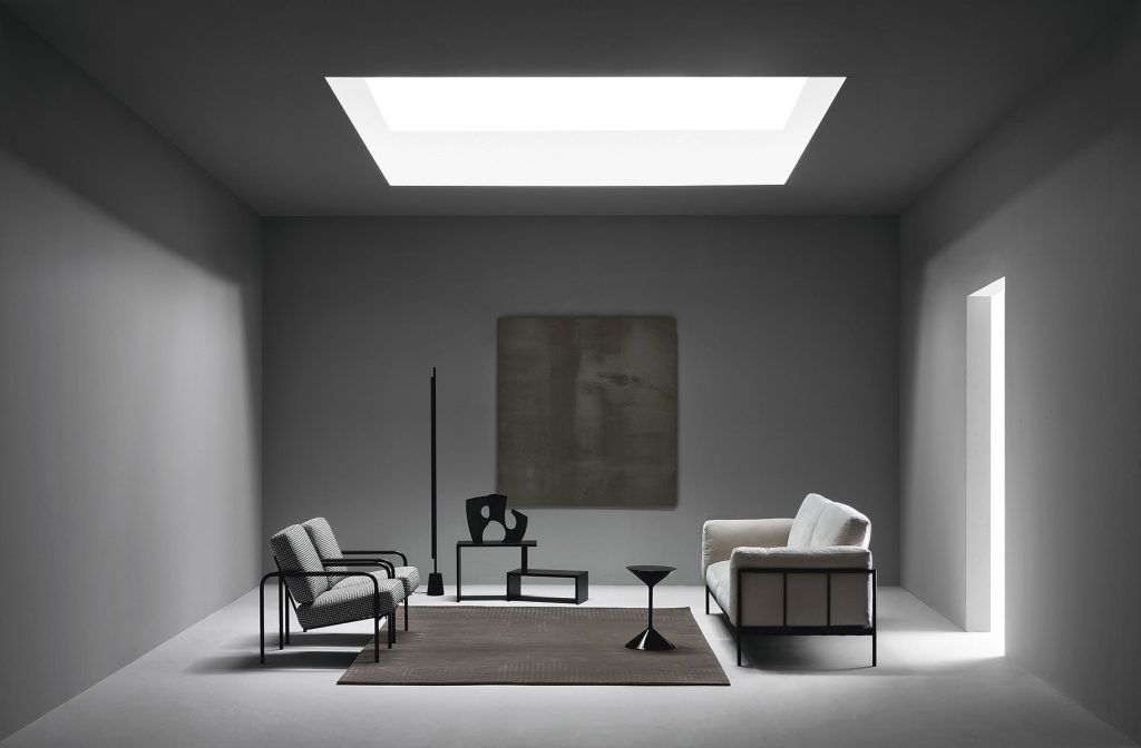 Two Susanna lounge chairs with a sleek metal frame and light gray cushioned seat and backrest in a living room.