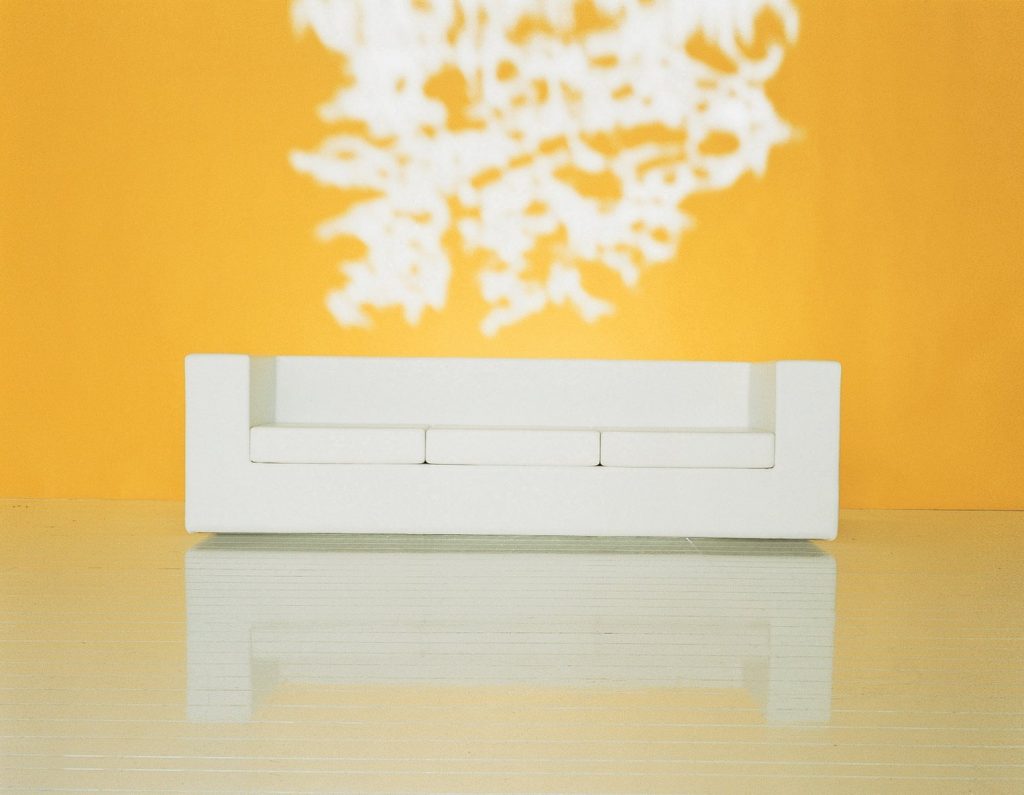 Throw-Away sofa featuring white fabric upholstery and a boxy shape on a yellow background.