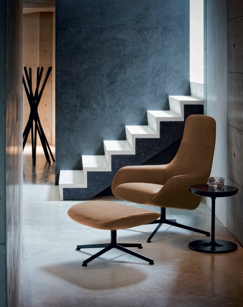 Toi side table with a round black top and central leg, in a living room.