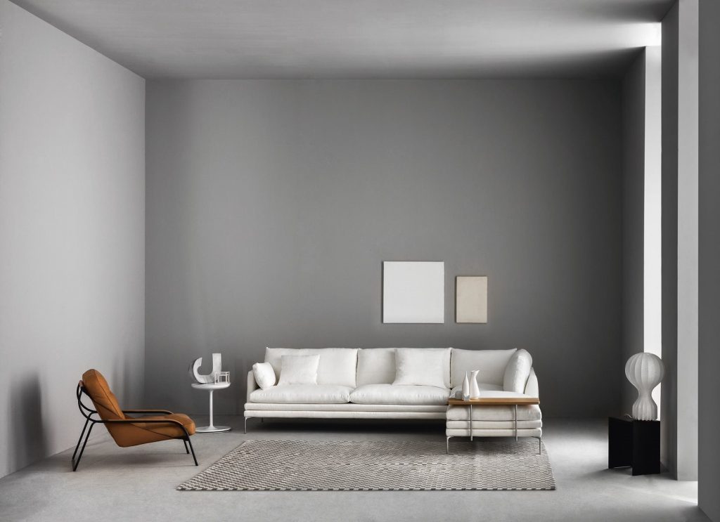 Toi side table with a round white top and central leg, in a living room.