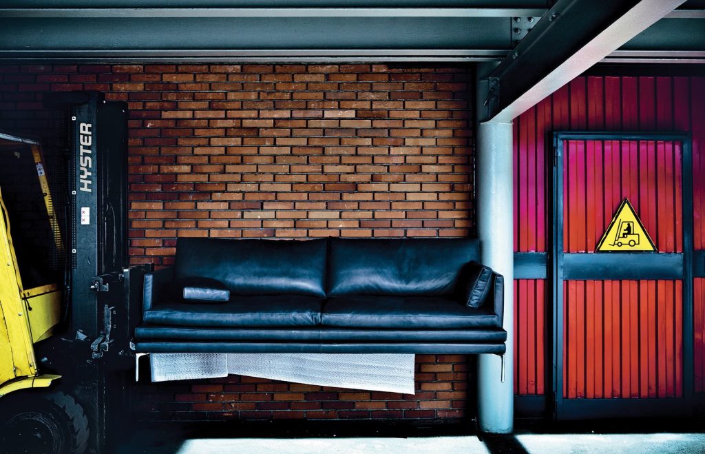 William sofa with a minimalist design, light black upholstery, and slim metal legs in a living room.