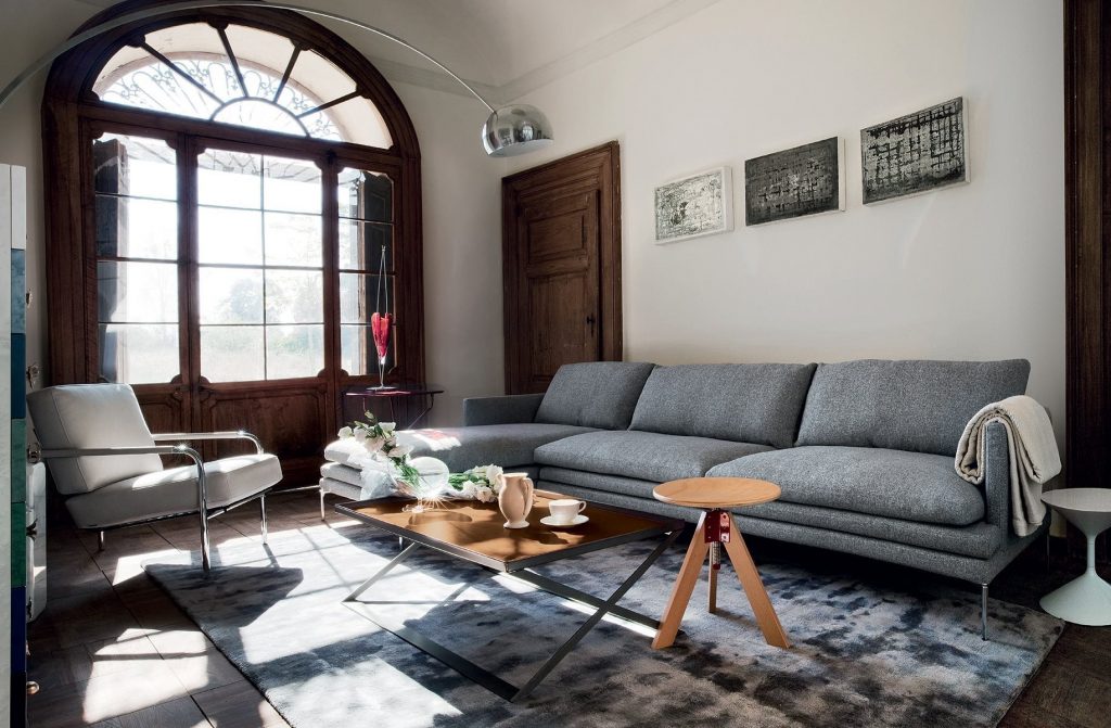 William sofa with a minimalist design, black upholstery, and slim metal legs in a living room.