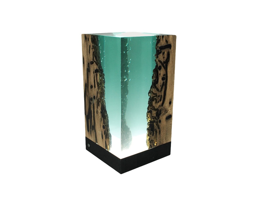 Abyss Lamp combines natural wood with a glowing resin core, creating a striking light piece. Its translucent body diffuses illumination softly, serving as both a functional lamp and a sculptural accent.