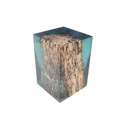This stool combines natural wood with translucent resin in a cubic form creating a striking piece that highlights raw textures and a modern aesthetic.