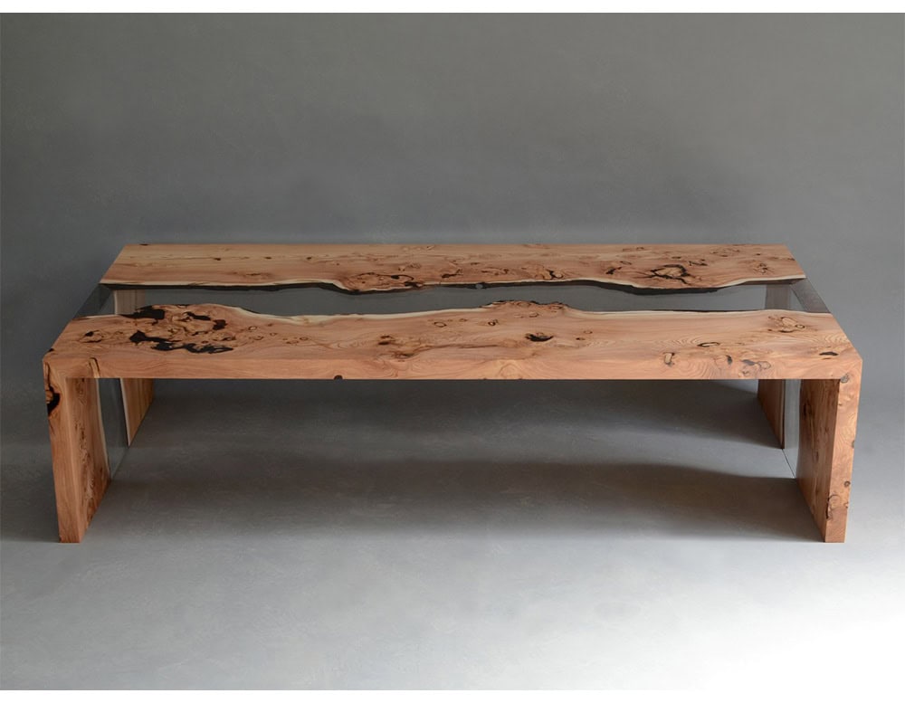A striking coffee table crafted from natural wood and resin, blending organic textures with sleek modern lines. Its flowing patterns evoke the look of a river, creating a sculptural centerpiece for any living space.