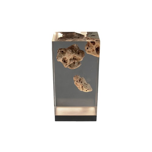 A sculptural lamp with embedded karst stones suspended in clear resin. The transparent block and concealed base light create an ethereal glow, blending geology and design into a striking functional piece.