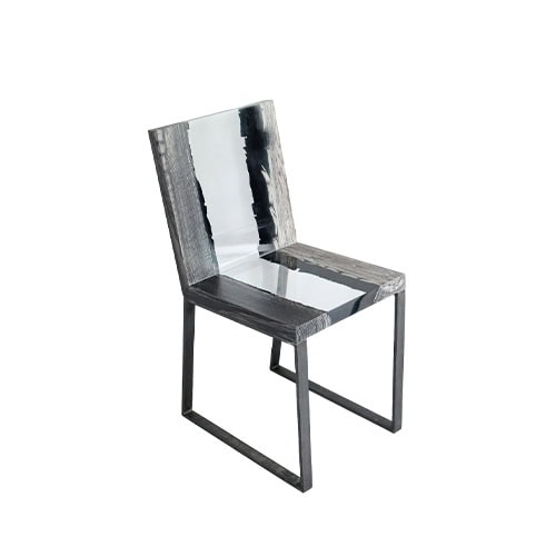 Peatland Chair presents charred wood encased in resin, set on a minimal metal frame. The blend of natural textures and sharp geometry gives it a refined yet sculptural character.