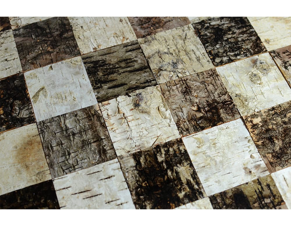 Phellem Chess Table displays a surface of cork squares in light and dark tones, arranged in a classic grid. The natural textures create a rich tactile pattern within a timeless design.