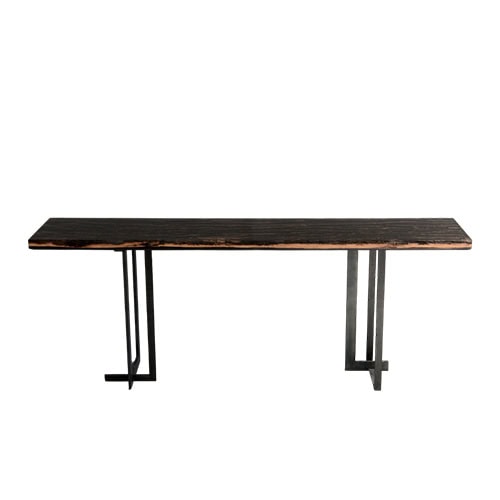 Phellem Console Table features a slim dark wood top with natural edges, supported by asymmetrical metal legs. Its minimalist structure and organic surface create a refined balance of raw and modern design.