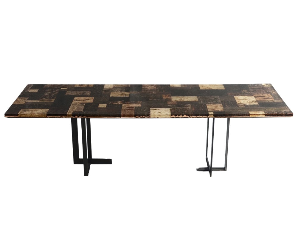 Phellem Dining Table features a patchwork cork surface in deep and light tones, supported by slim metal legs. The geometric pattern and natural texture create a bold yet refined dining centerpiece.