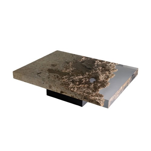 Rapolano Low Table showcases a stone inspired surface with raw textures captured in clear resin. Its wide rectangular top rests on a discreet base, blending rugged detail with sleek geometry.