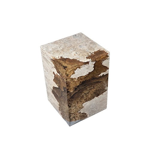 Rapolano Stool presents raw stone textures suspended in resin, shaped into a sleek cube form. The contrast of rugged surfaces and polished finish creates a bold sculptural accent.