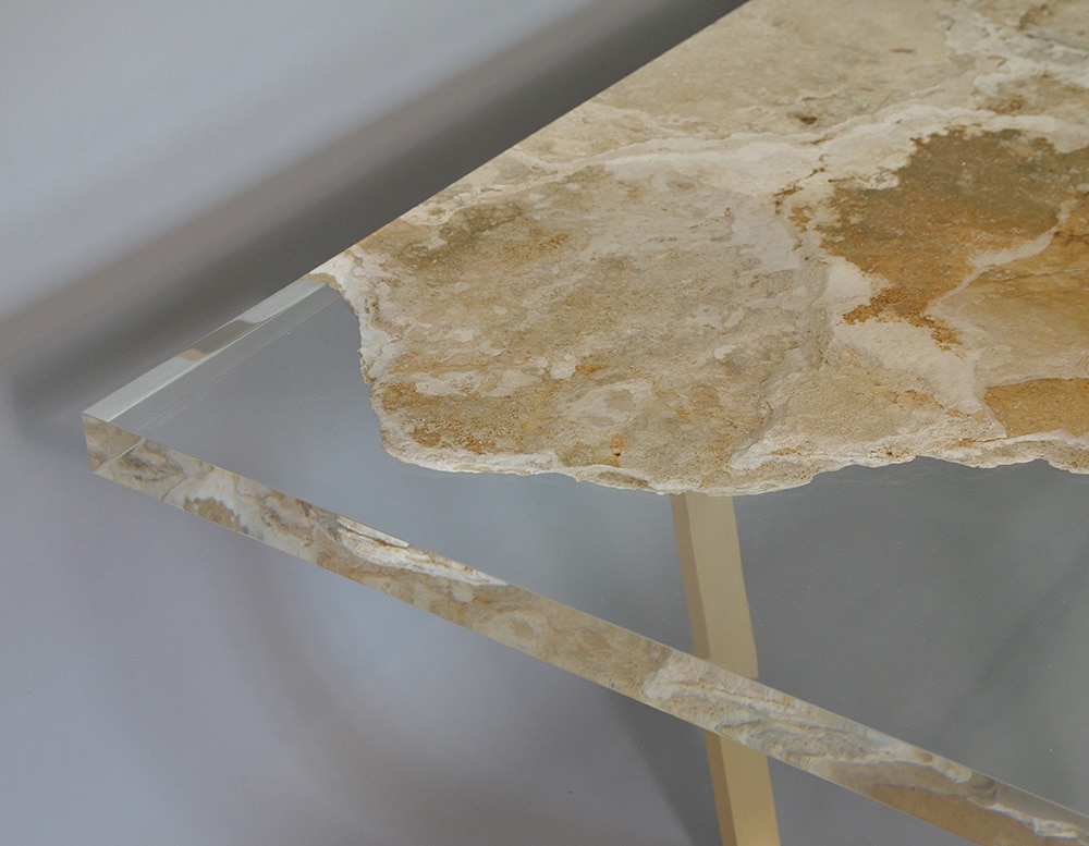 table made of travertine rock and glass in transparent and golden color tone