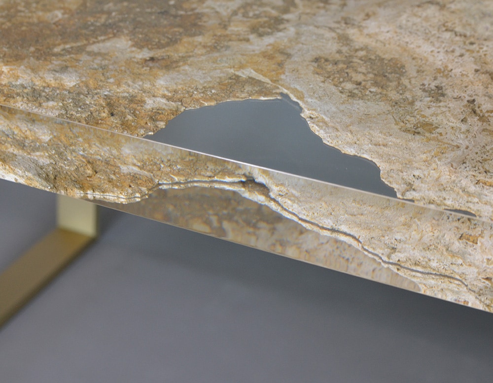 table made of travertine rock and glass in transparent and golden color tone