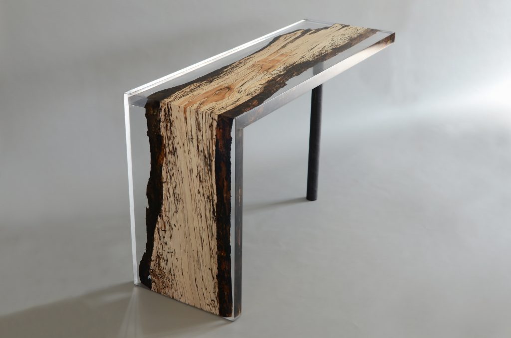 Fungi Console with an elongated, rectangular shape, made of wood with a natural finish and featuring a transparent resin inlay, set against a white background.