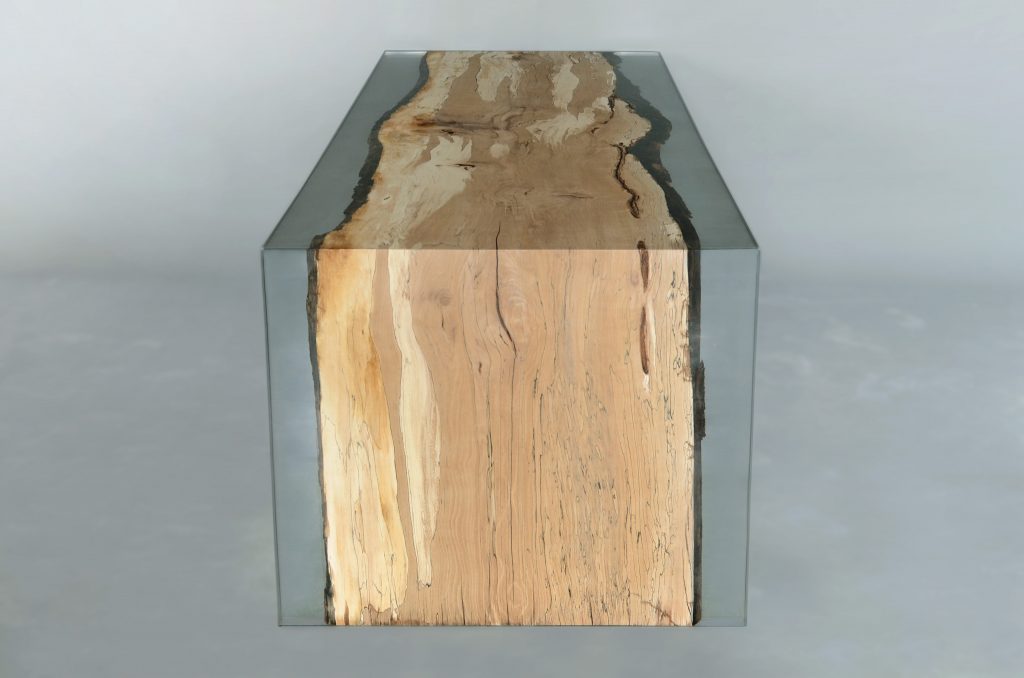Fungi Dining Table with an organic, rectangular shape, made of wood with a natural finish and featuring a transparent resin inlay, set against a gray background.