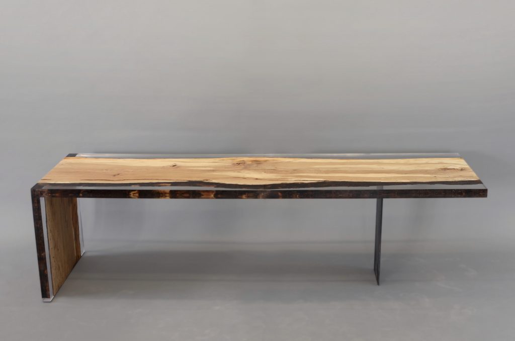 Fungi Dining Table with an organic, rectangular shape, made of wood with a natural finish and featuring a transparent resin inlay, set against a gray background.