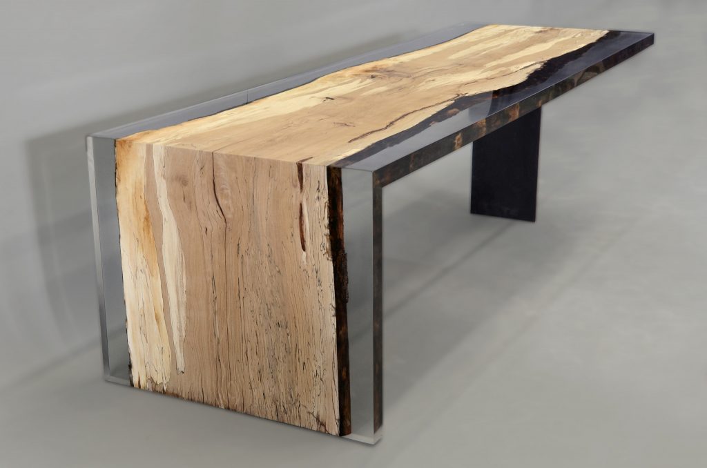 Fungi Dining Table with an organic, rectangular shape, made of wood with a natural finish and featuring a transparent resin inlay, set against a gray background.