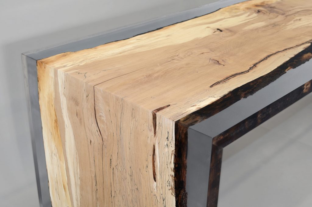 Fungi Dining Table with an organic, rectangular shape, made of wood with a natural finish and featuring a transparent resin inlay, set against a gray background.