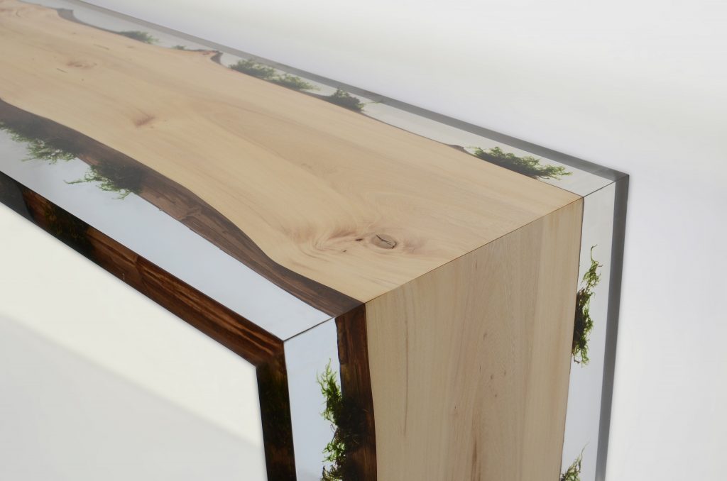 table console made of light wood with edges made of alcarol resin based on a natural tree on a gray background