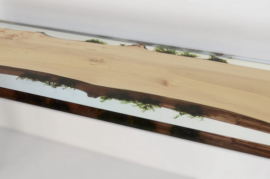 table console made of light wood with edges made of alcarol resin based on a natural tree on a gray background