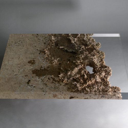 small plate made of natural stone and transparent glass in a brown tone on a gray background