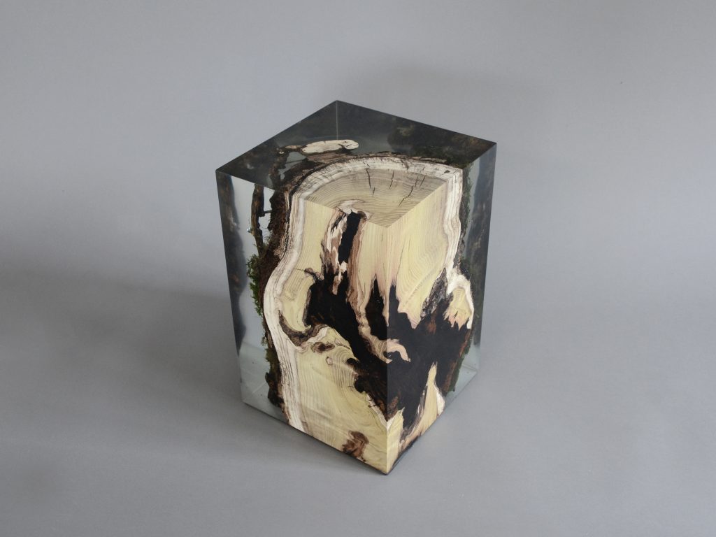 stool made of natural wood base covered in transparent resin in the shape of a cube on a gray background
