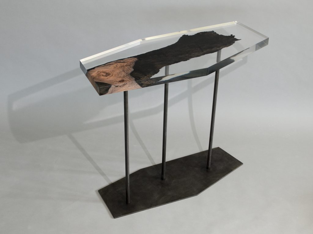 table made of resin and natural wood in the shape of a hexagon resting on a base of steel legs