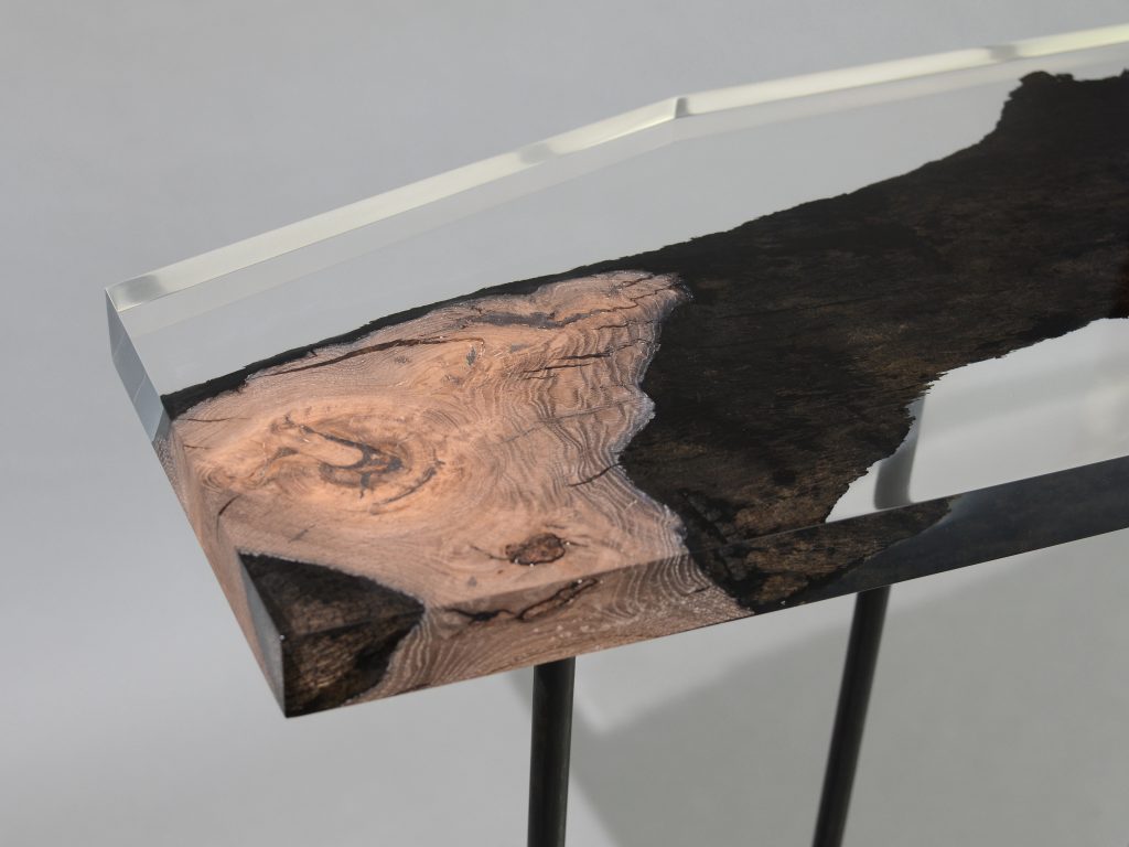 Natural wood table completely covered in transparent resin in the shape of a hexagon