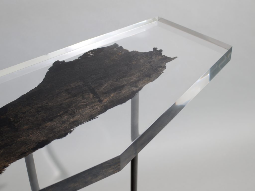 Natural wood table completely covered in transparent resin in the shape of a hexagon